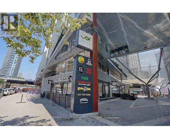 A street view of a shopping center with various stores including Montfort, Chasera, and a brew pub.