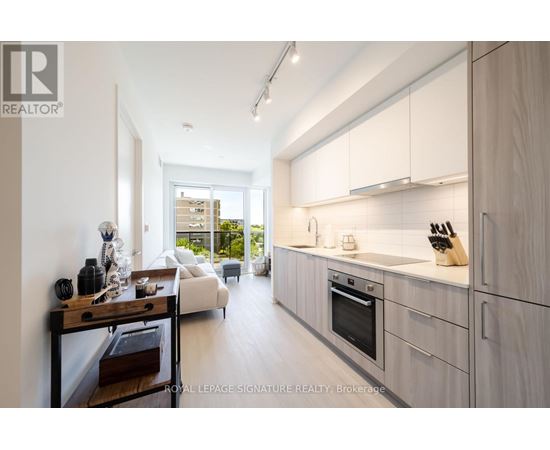 A modern kitchen with white cabinets and a view of the backyard.
