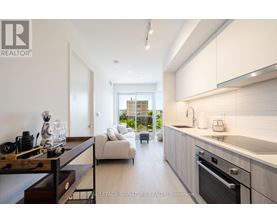 A modern kitchen with white cabinets and a wooden countertop.