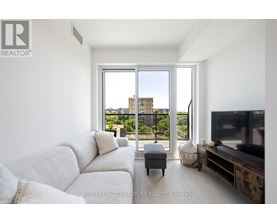 A living room with a white couch and a television.
