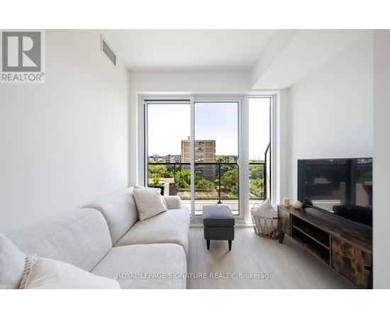 A living room with a white couch and a television.