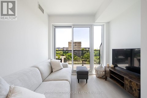 A living room with a white couch and a television.
