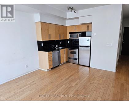 A kitchen with wooden cabinets and black countertops.