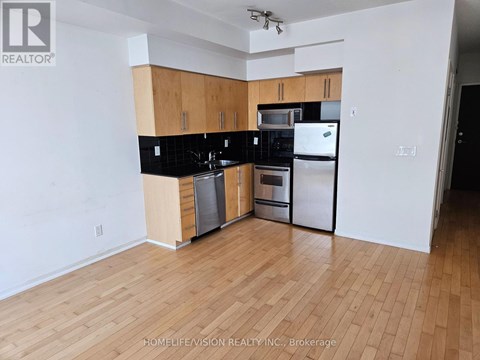 A kitchen with wooden cabinets and black countertops.