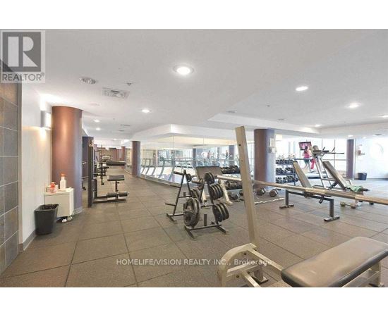 A gym with a variety of equipment including weights and benches.