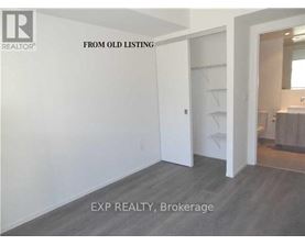 A room with a white door and a grey floor.