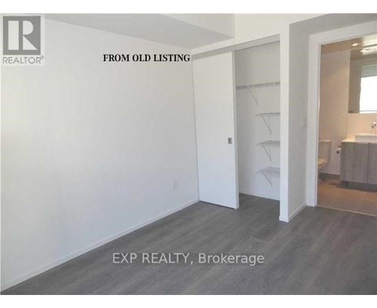 A room with a white door and a grey floor.