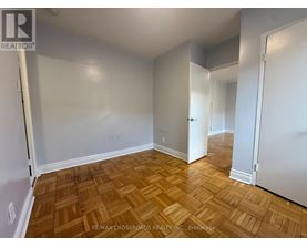 A room with wooden flooring and white walls.