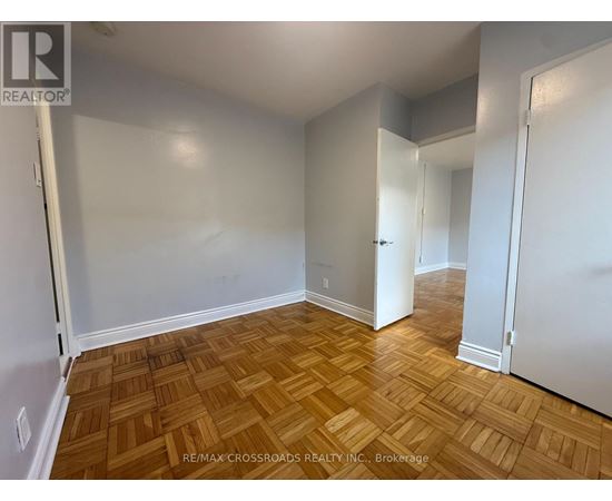 A room with wooden flooring and white walls.