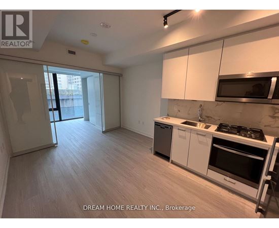 A kitchen with white cabinets and a black stove top oven.