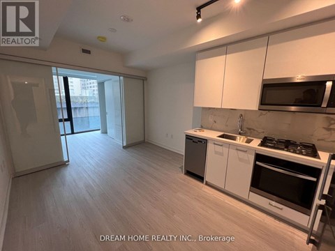 A kitchen with white cabinets and a black stove top oven.