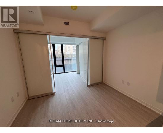 A room with a sliding door leading to a balcony.