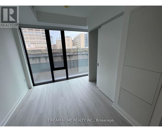A room with a view of the city through a large window.