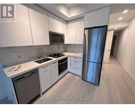 A kitchen with white cabinets and a stainless steel refrigerator.
