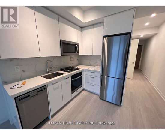 A kitchen with white cabinets and a stainless steel refrigerator.