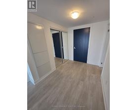 A room with a wooden floor and a black door.