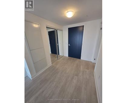A room with a wooden floor and a black door.