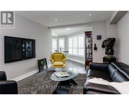 A living room with a yellow chair and a black couch.