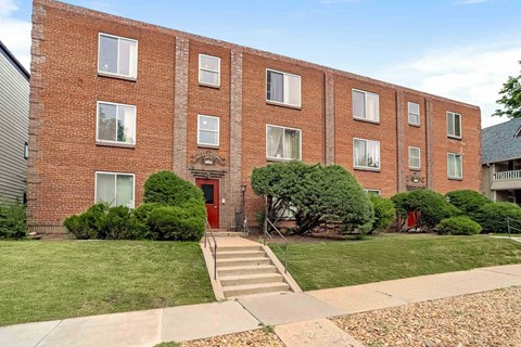 A red brick building with a red door and windows.