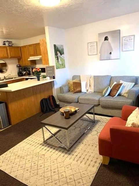A living room with a grey couch and a red chair.