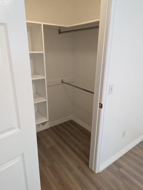A white closet with a shelf and a hanger.