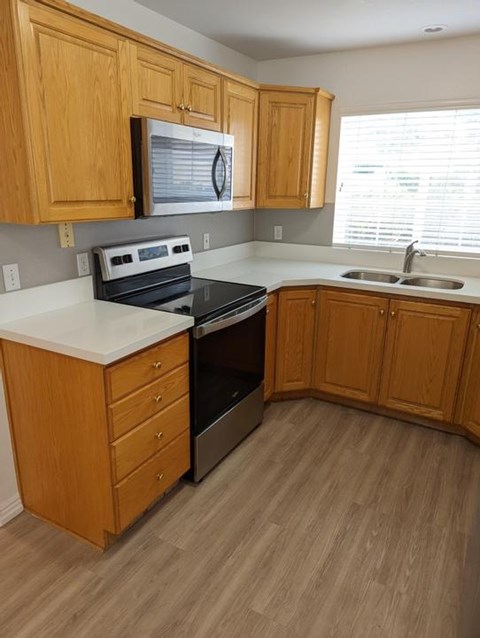 A kitchen with wooden cabinets and a black stove top oven.