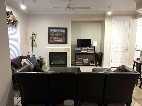 A living room with a fireplace and a painting on the wall.