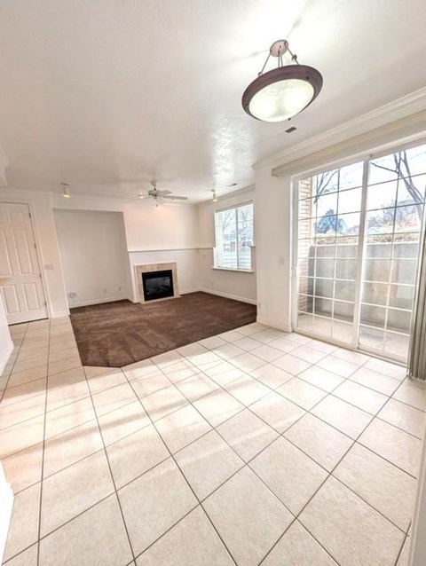 A living room with a fireplace and a ceiling fan.