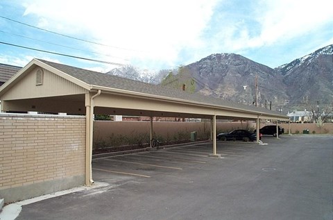 A parking lot with a building and a mountain in the background.