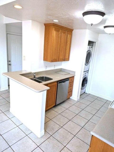 A kitchen with a white counter top and wooden cabinets.