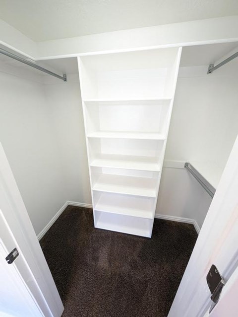 A white shelving unit in a room with white walls.