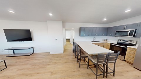 A modern kitchen with a long table and chairs.