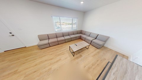 A living room with a large sectional sofa and a coffee table.