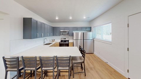 A kitchen with a table and chairs.