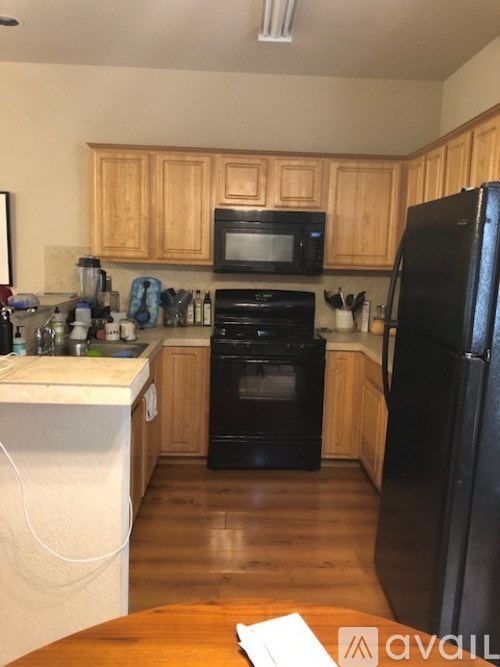 A kitchen with black appliances and wooden cabinets.
