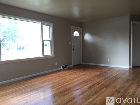 A room with wooden floors and a large window.