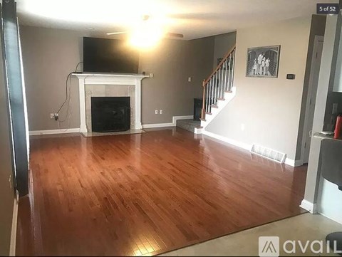A living room with a fireplace and a television on the wall.