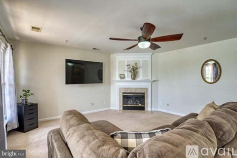 A living room with a fireplace and a television mounted on the wall.