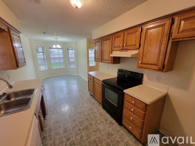 A kitchen with wooden cabinets and a black stove top oven.