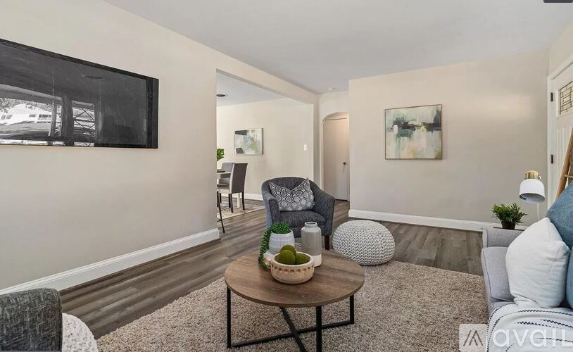 A living room with a grey couch, a coffee table, and a painting on the wall.