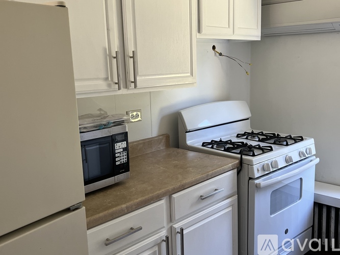 A kitchen with a white gas stove and a microwave on the counter.