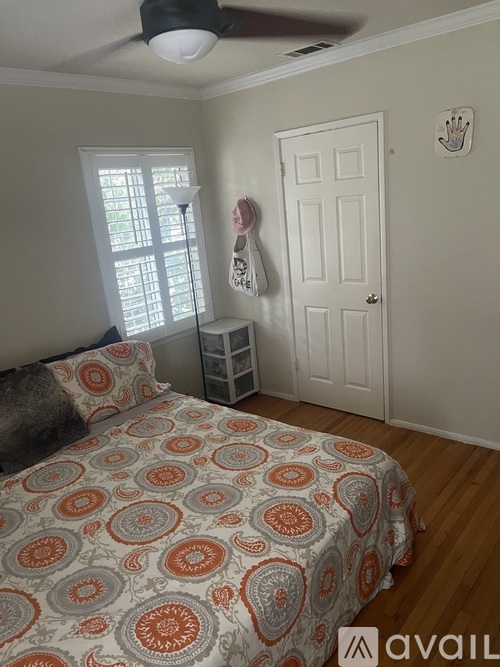 A bedroom with a bed, a window, and a door.