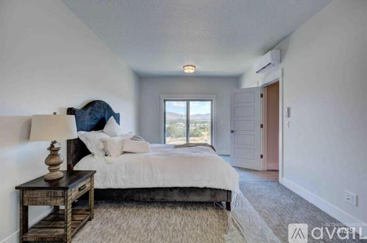 A bedroom with a large bed and a window overlooking the outdoors.