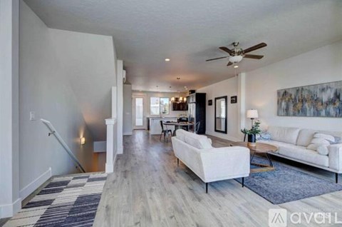 A living room with a white couch and a ceiling fan.