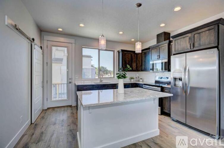 A modern kitchen with a large island and stainless steel appliances.