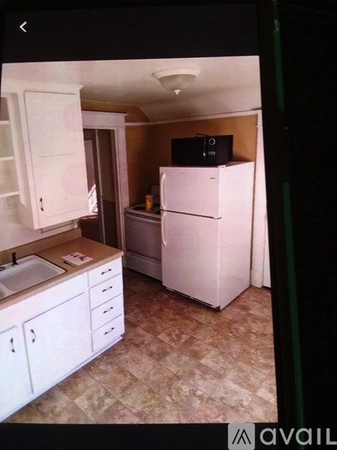 A kitchen with white cabinets and a white refrigerator.