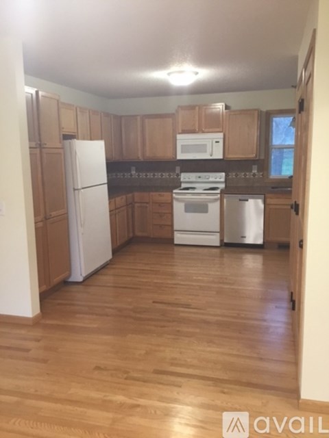 A kitchen with wooden cabinets and a white fridge.