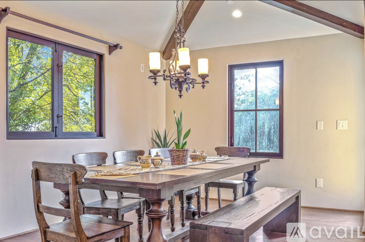 A dining room with a wooden table and chairs.