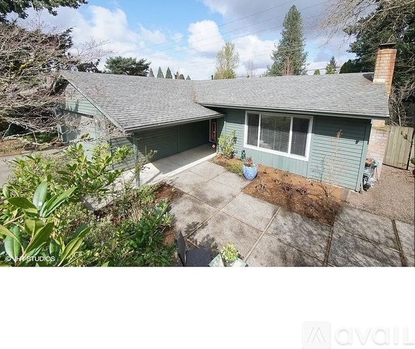 A house with a grey roof and a green garage door.