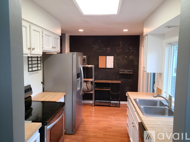 A kitchen with a black stove top oven and a black fridge.